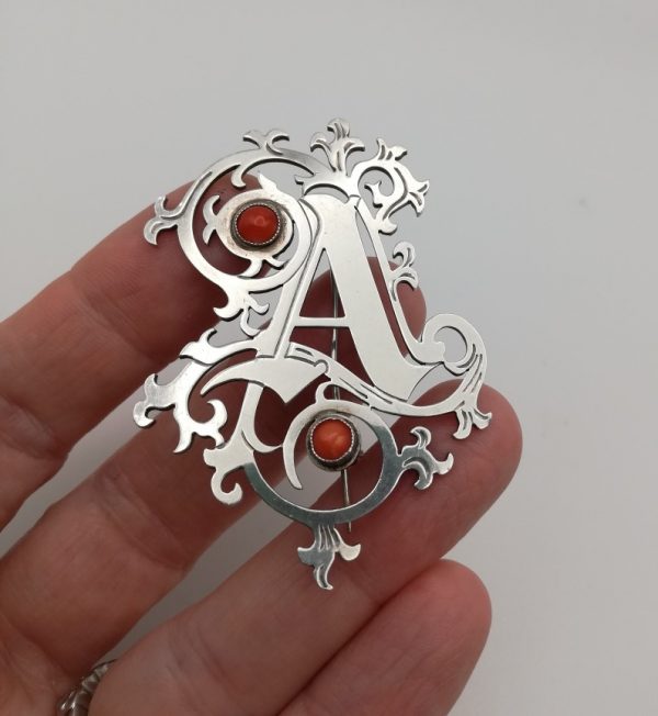 Arts and Crafts letter A ornate silver brooch with coral cabochons, London HM 1991
