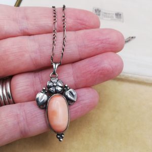 Arts and Crafts c1910 foliate pendant necklace in silver with Angel Skin coral cabochon, barrel fastener